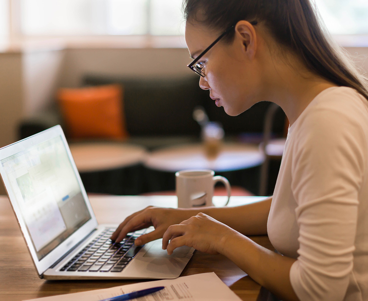 young adult female typing on laptop