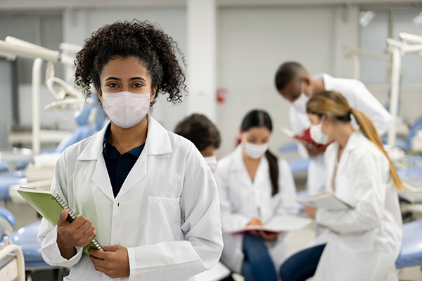 african american female wearing a mask holding a clipboard