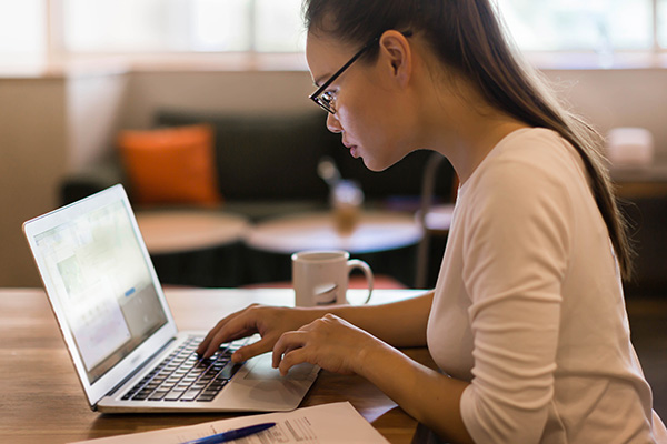 young adult female typing on laptop