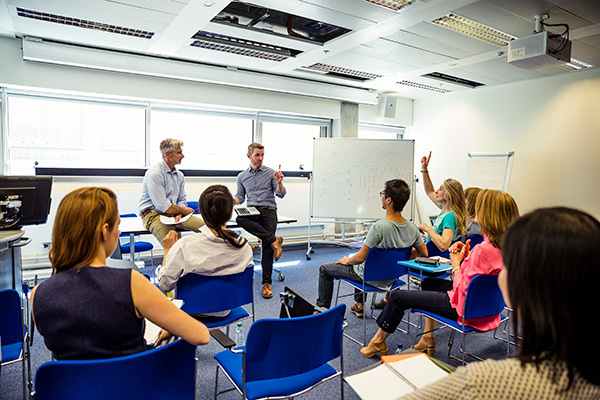 classroom with students in chairs asking questions