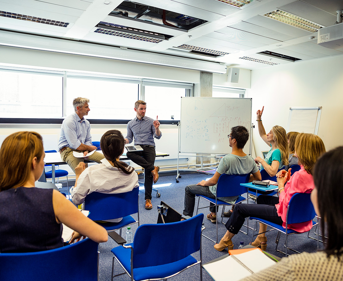 classroom with students in chairs asking questions