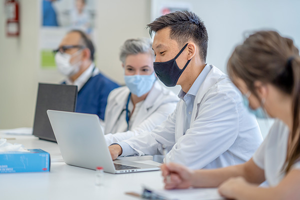 male doctor wearing mask on laptop