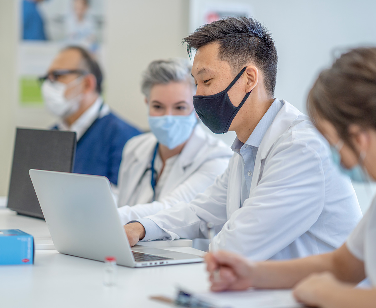 male doctor wearing mask on laptop