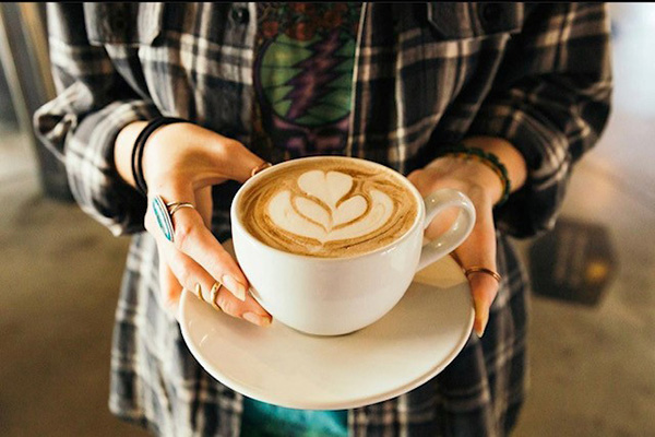 man holding coffee cup on plate