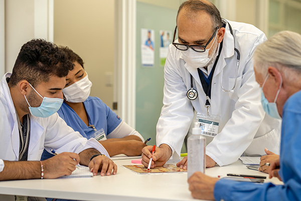 older male doctor meeting other doctors